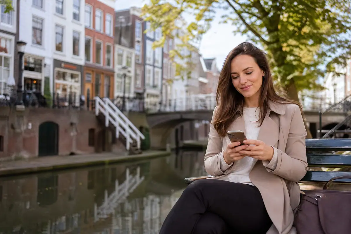 Vrolijke dame langs de gracht in Utrecht stelt een hulpvraag via haar mobiel